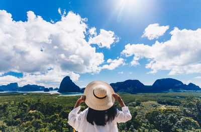 Rear view of woman looking at mountains against sky