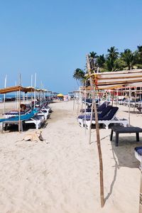 Boats moored at beach against clear blue sky