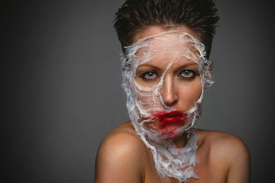 Portrait of a young woman against black background