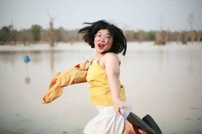 Portrait of smiling young woman standing in lake