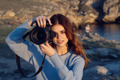 Portrait of young woman photographing
