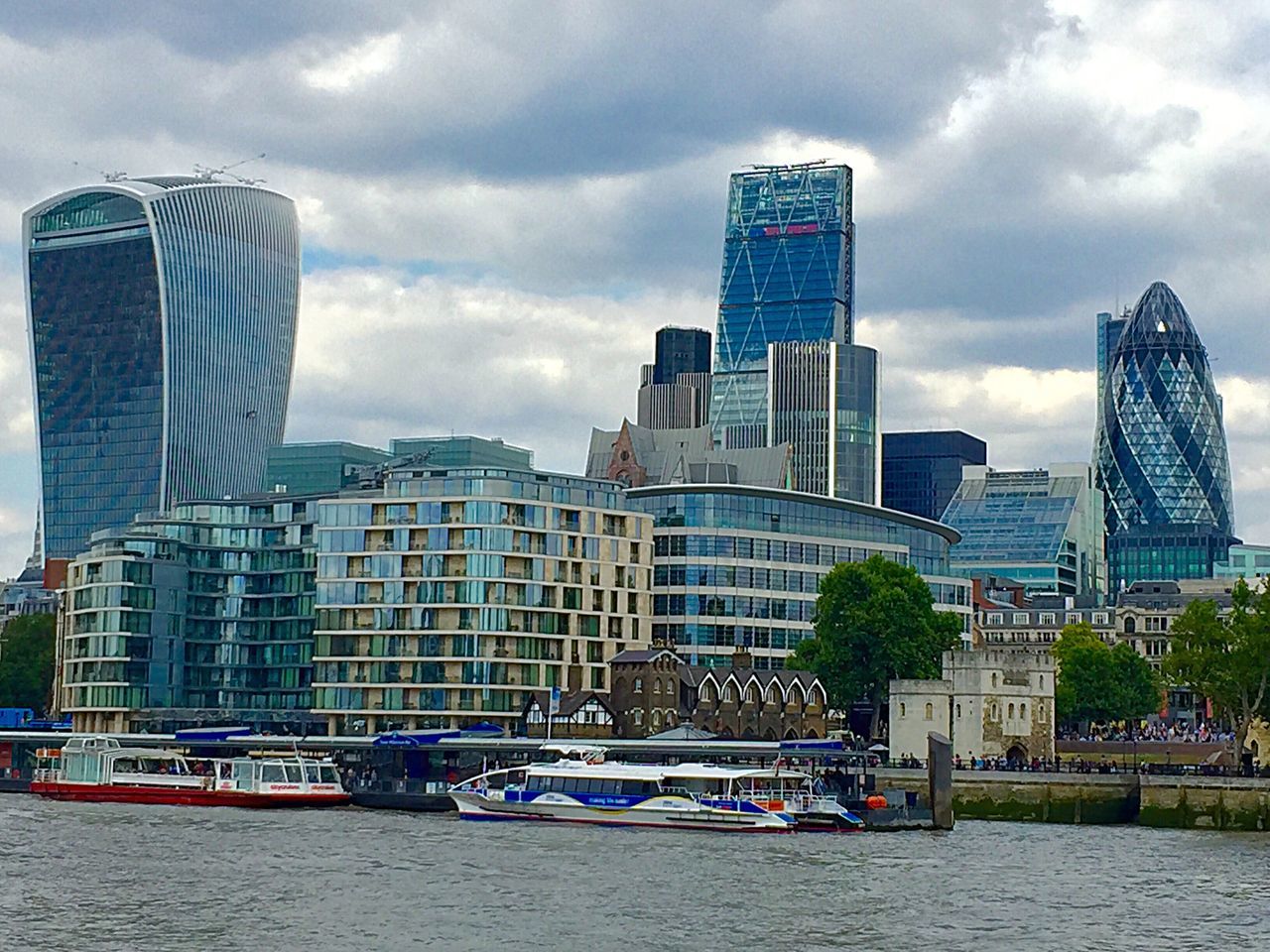 building exterior, architecture, built structure, sky, skyscraper, city, modern, cloud - sky, water, waterfront, tall - high, tower, office building, cloudy, cloud, travel destinations, capital cities, cityscape, day, travel