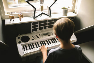 Boy playing piano at home