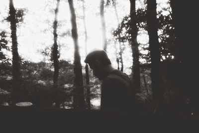 Silhouette woman standing by trees in forest