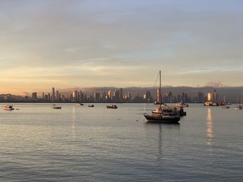 Scenic view of sea and buildings against sky during sunset