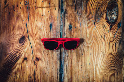 Directly above view of red sunglasses on wooden table