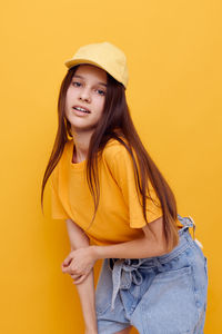 Portrait of girl against yellow background
