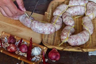 High angle view of person preparing sausage with spices at kitchen counter