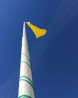 Low angle view of flag against blue sky