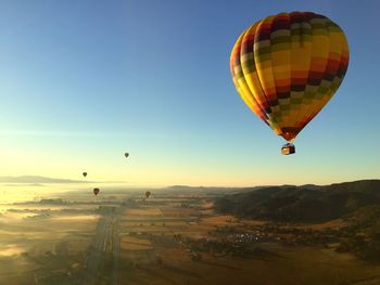 Hot air balloons flying over landscape