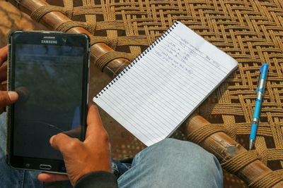 Midsection of man using mobile phone