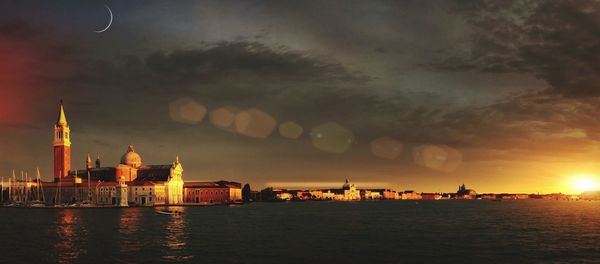 Buildings at waterfront during sunset