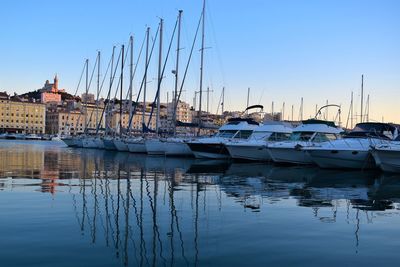 Sailboats moored in harbor