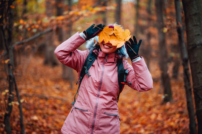 Midsection of woman holding autumn leaves