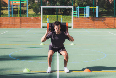 Athlete with a barbell on his back performs a lunge to strengthen the trunk and lower part of body