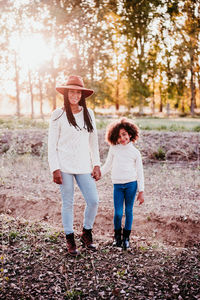 Full length of smiling woman standing on land