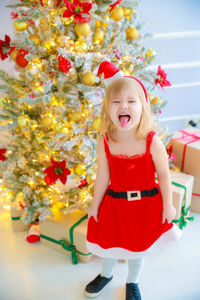 Full length of girl in christmas tree