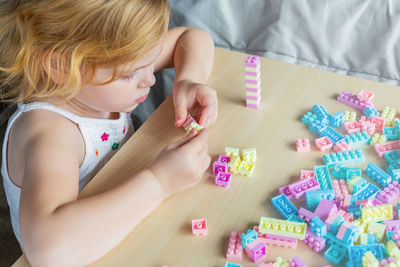 High angle view of girl playing on table