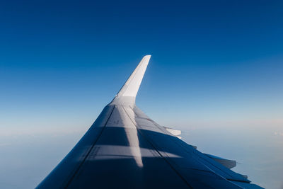 Airplane wing against blue sky