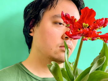 Close-up portrait of woman with red flower