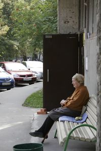 Side view of woman sitting on bench