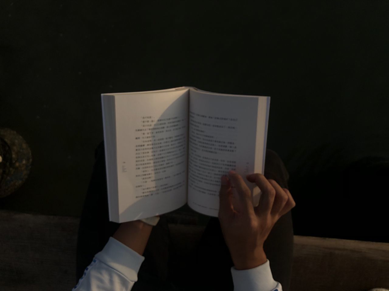 MIDSECTION OF PERSON READING BOOK AGAINST PAPER