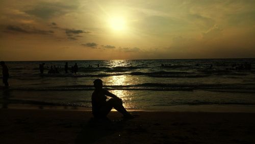 Silhouette of man standing at beach during sunset