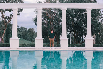 Reflection of man standing on swimming pool
