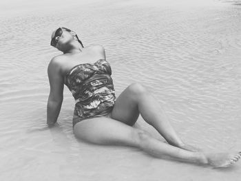 Young woman wearing swimwear while relaxing in sea