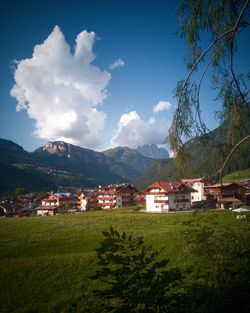 Houses by buildings against sky in city