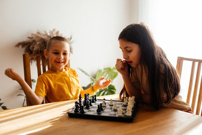 Cute kids playing chess at home