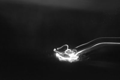 Close-up of illuminated lighting equipment against black background