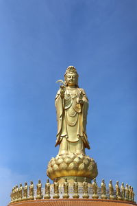 Low angle view of statue against blue sky