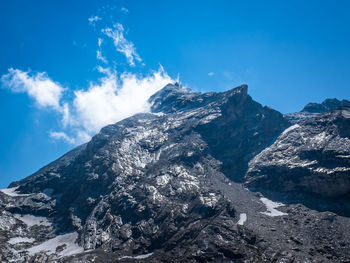 Aerial view of snowcapped mountains against blue sky