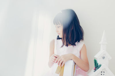Rear view of young woman standing against white background