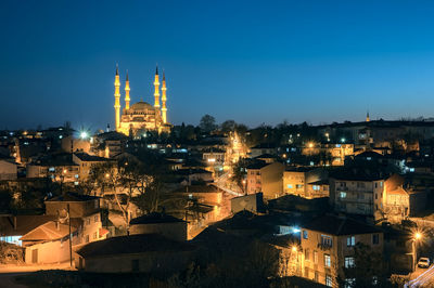 Illuminated buildings in city against sky