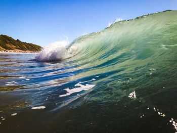 Scenic view of sea waves splashing against sky