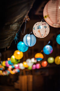 Low angle view of illuminated lighting equipment hanging on ceiling