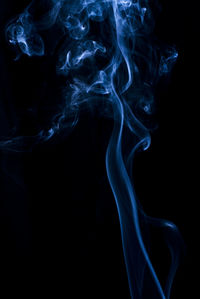 Close-up of blue smoke against black background