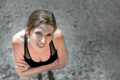 Portrait of young woman standing against wall