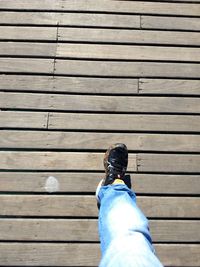 Low section of man standing on wooden floor