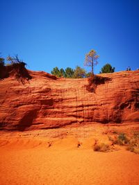 Rock formations on landscape against clear blue sky