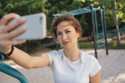 Portrait of young woman using mobile phone outdoors