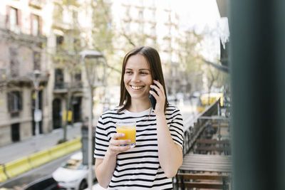 Portrait of smiling man standing on mobile phone