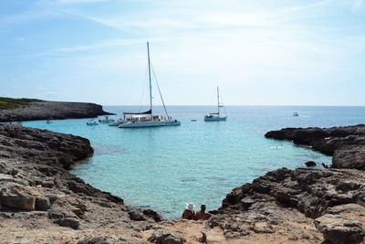 Sailboats sailing in sea against sky