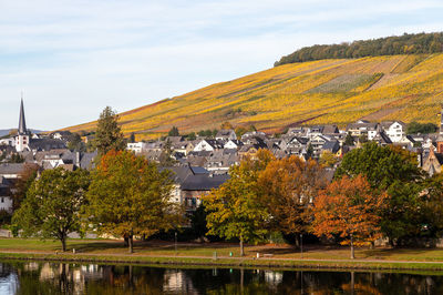 Scenic view of lake by buildings against sky