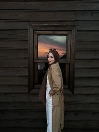 Rear view of woman standing against wall