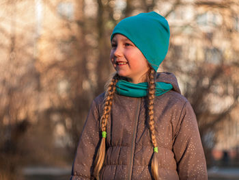 Portrait of smiling woman standing against tree during winter
