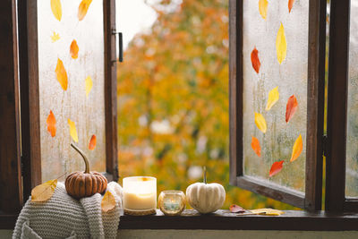 Still life details in home on a wooden window. sweater, candle, hot tea and autumn decor