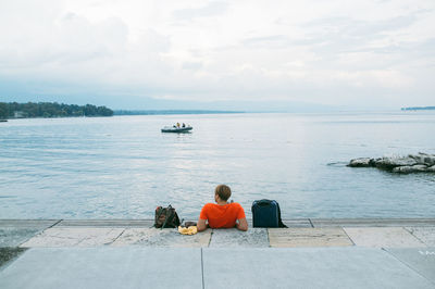 Rear view of people sitting on boat at sea